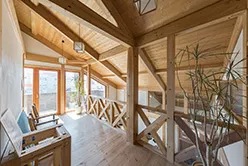 階段とハンモックが特徴的なリビングルーム。木目の内装が暖かい雰囲気を演出している。