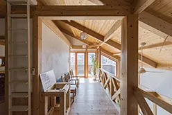 日差しの差し込むリビングルーム。木製の床と白い壁が調和している。