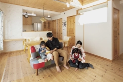 リビングでくつろぐ家族。カラフルなソファに座り、親子で暖かな時間を過ごしている。