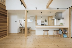 明るく開放的なダイニングキッチン。カウンタースペースと木製のスツールが配置されている。