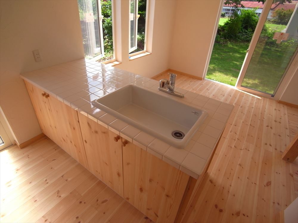 白いタイル張りのシンクカウンターが特徴