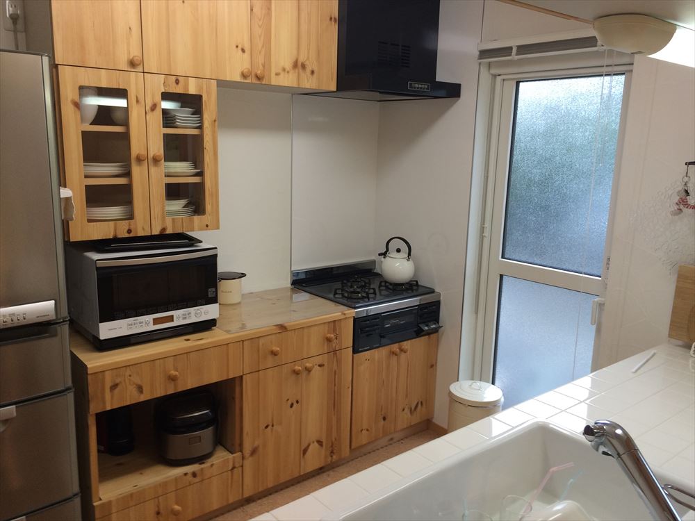 木製キャビネットと最新の調理家電が配置された空間