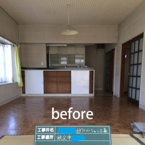 暗めの床と壁に古びた印象のキッチン