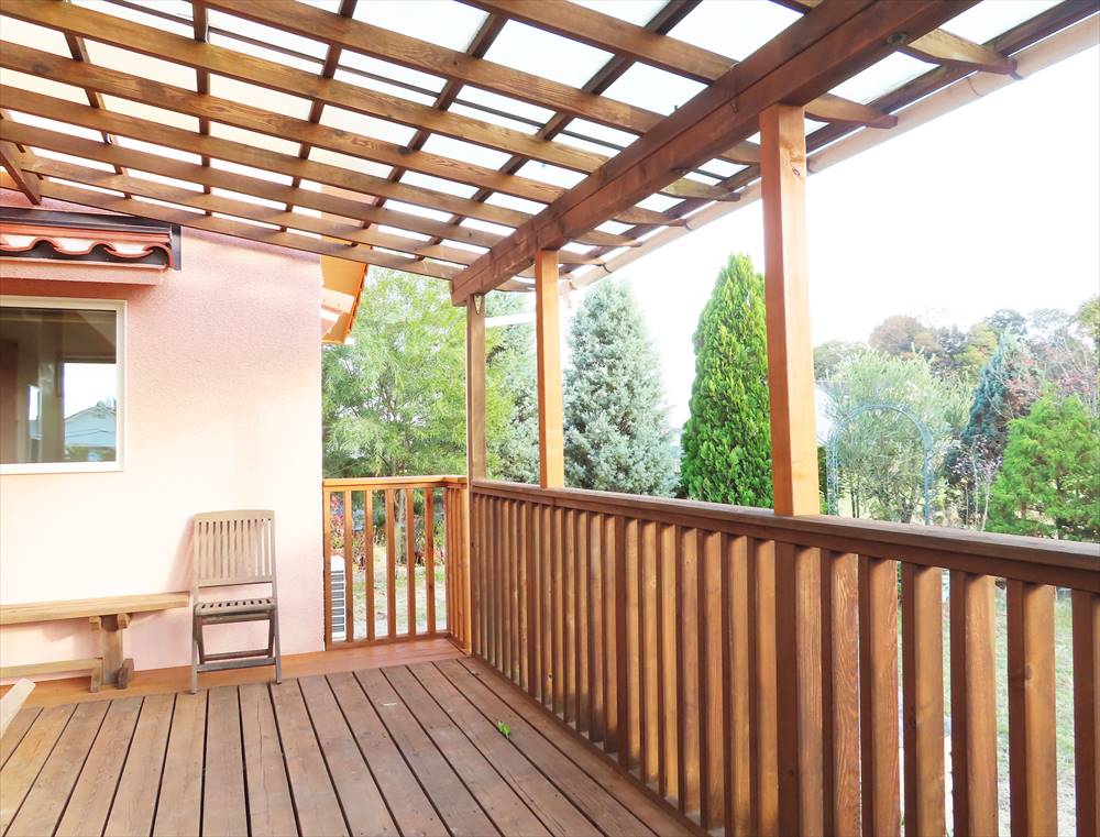 木製の手すりとピンクの外壁が調和している