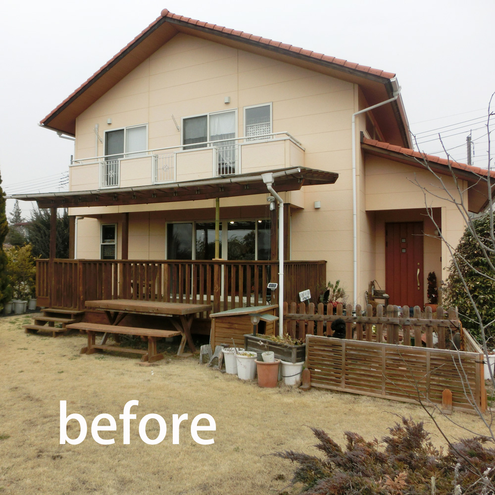 ベージュの外壁とウッドデッキが特徴の二階建て住宅